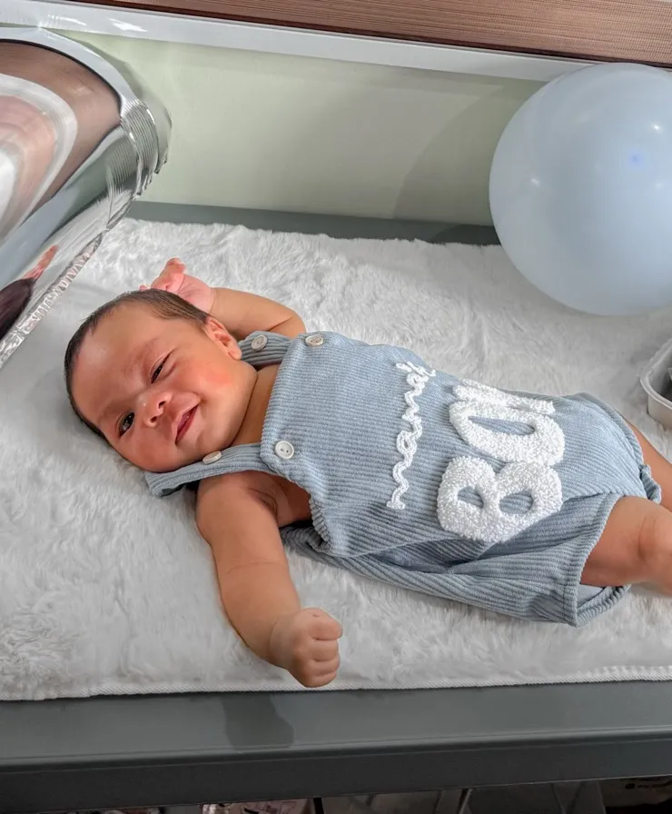 Baby Louis smiling in his mama's boy romper
