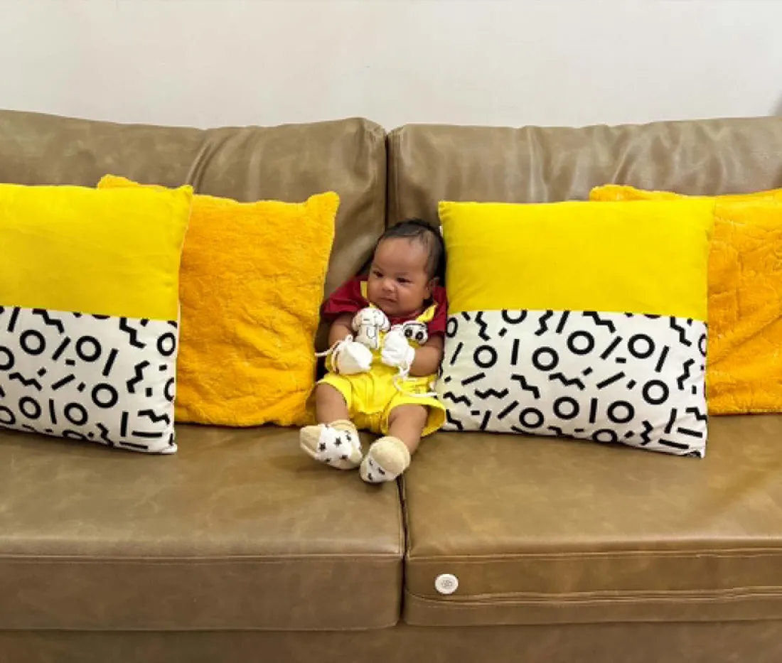 Baby Louis sitting up on the couch