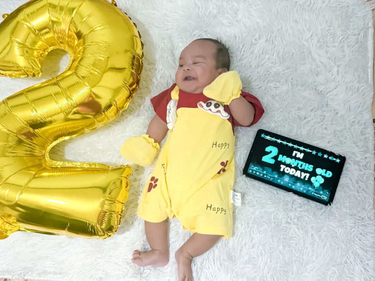 Baby Louis smiling in his yellow romper