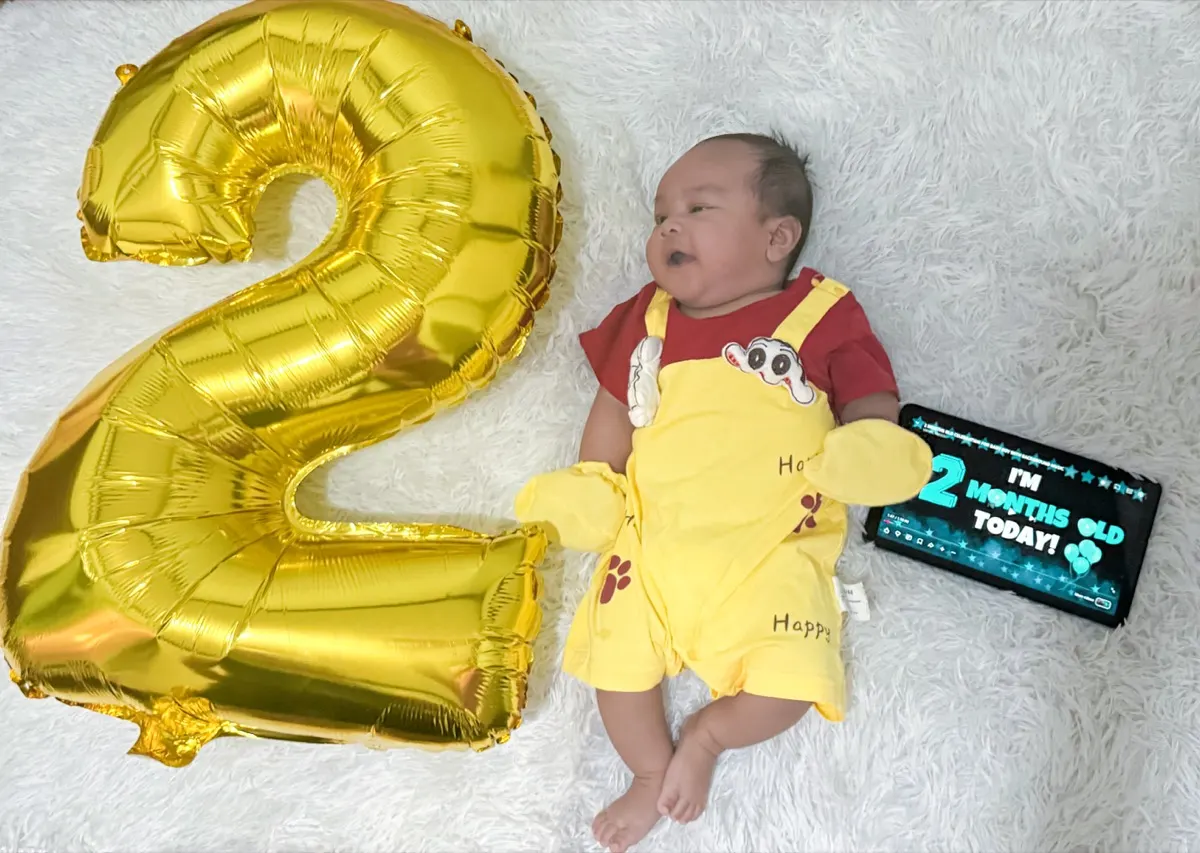 Baby Louis wide awake beside the balloon