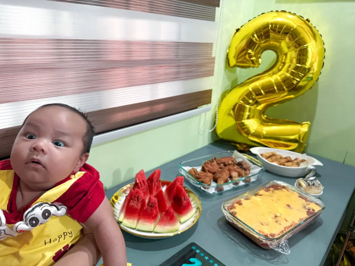 Baby Louis beside the party table